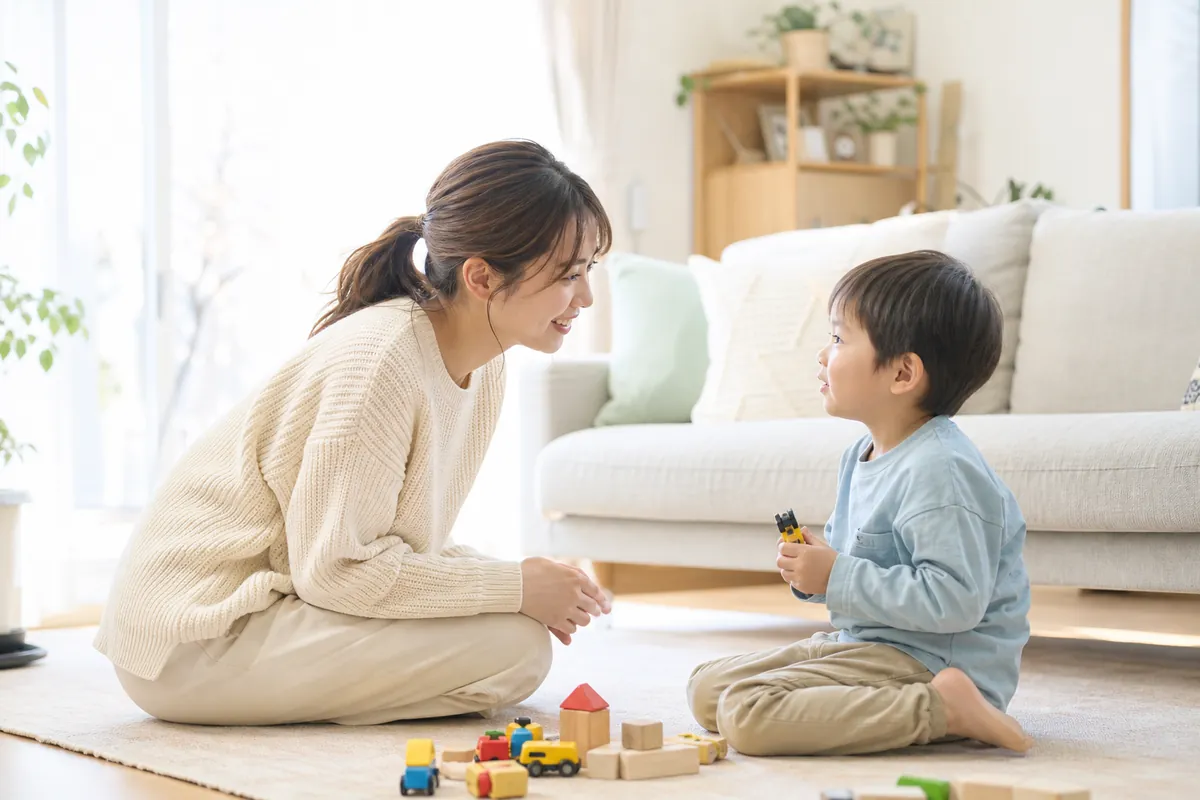 子供と目線を合わせて話しかけるママ