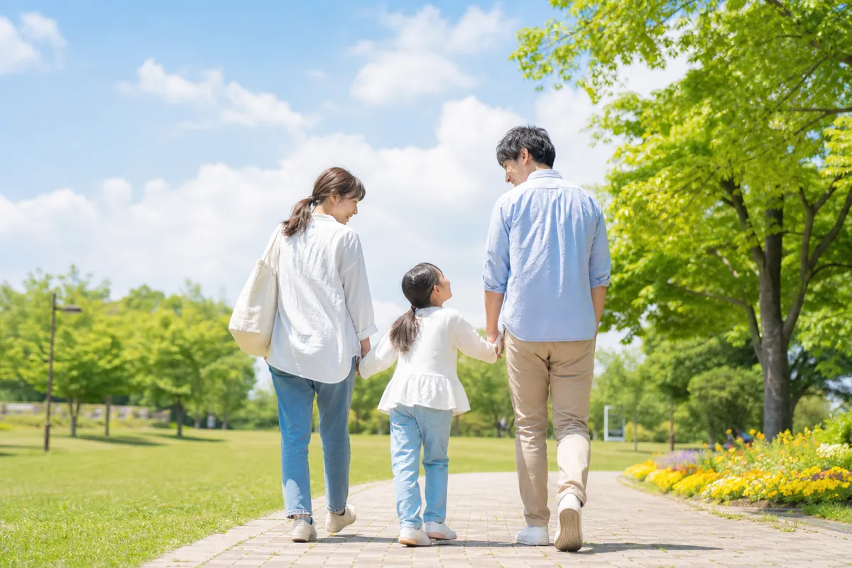 公園で手をつないで歩く家族