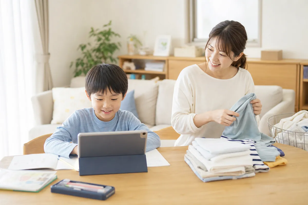 タブレットで学ぶ小学生を見守るママ