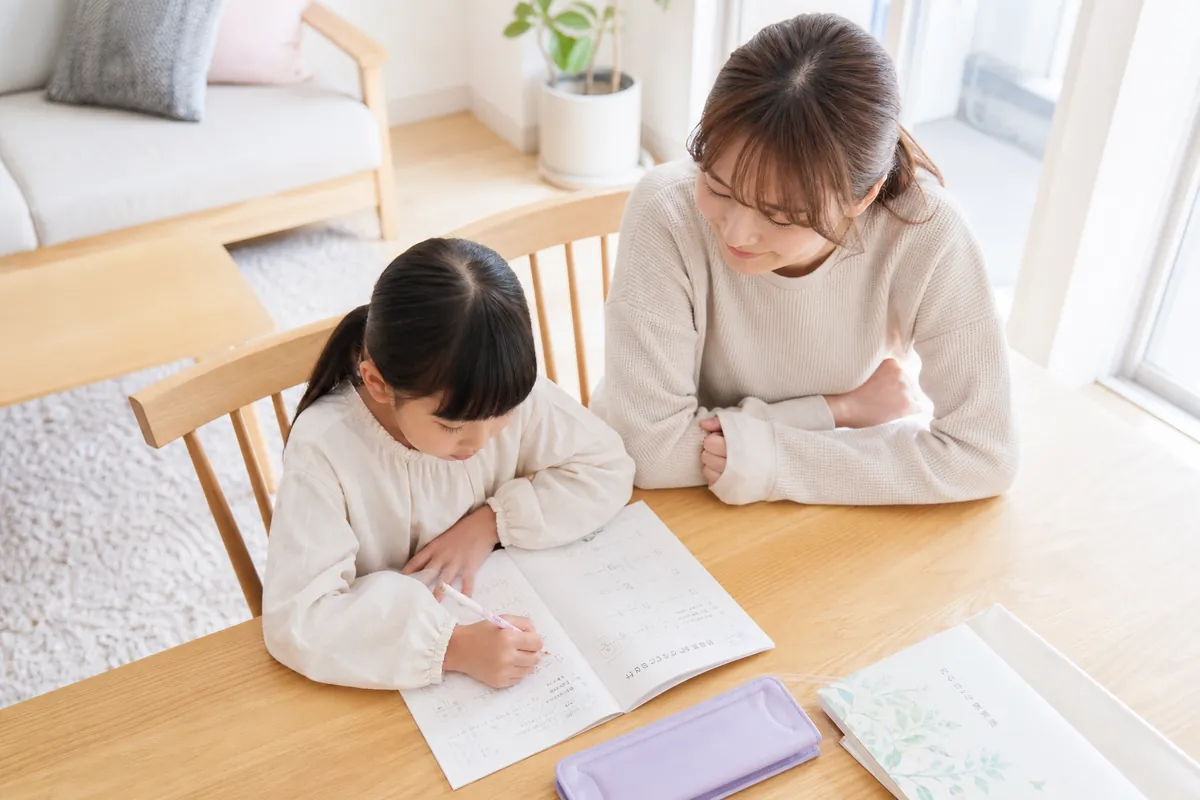 紙のワークに取り組む小学生とママ
